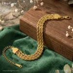 About Detailed view of the gold lobster clasp, triangular end caps, and adjustable extender chain of a triple-strand bracelet