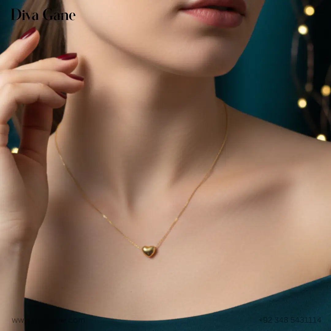 the amora minimalist 3d gold heart charm Close-up detail of a minimalist golden heart charm necklace, highlighting the high-shine finish and delicate link chain