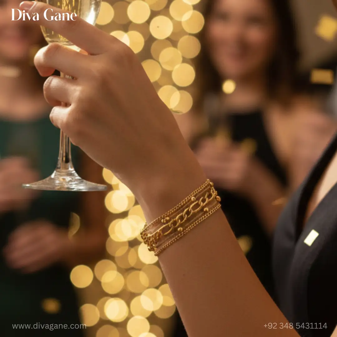 gold harmony layered bracelet Close-up of a gold statement multi-strand bracelet on a woman's arm at a gala event with bokeh party lights in the background.